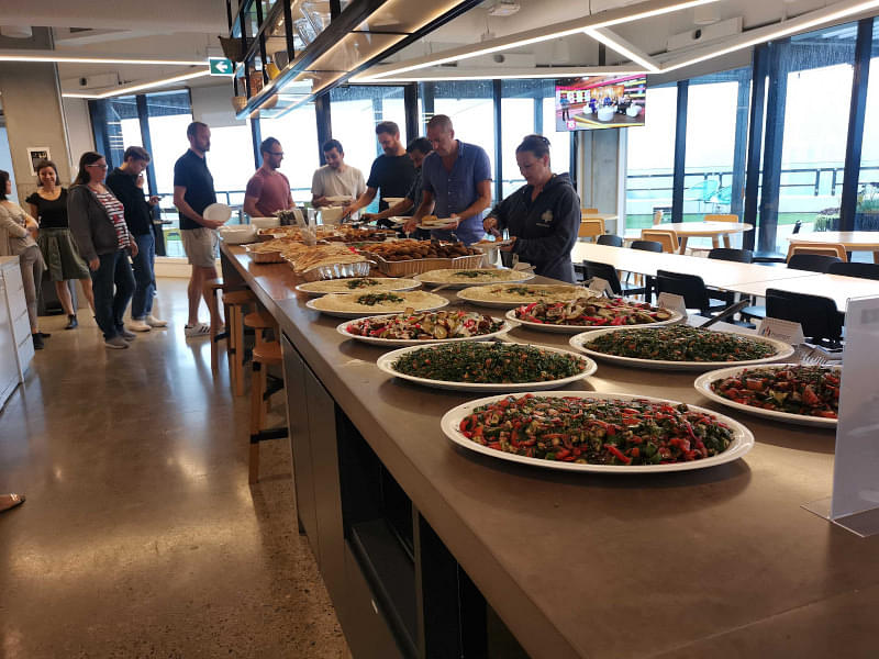Staff eating a spread of food at a customer's office